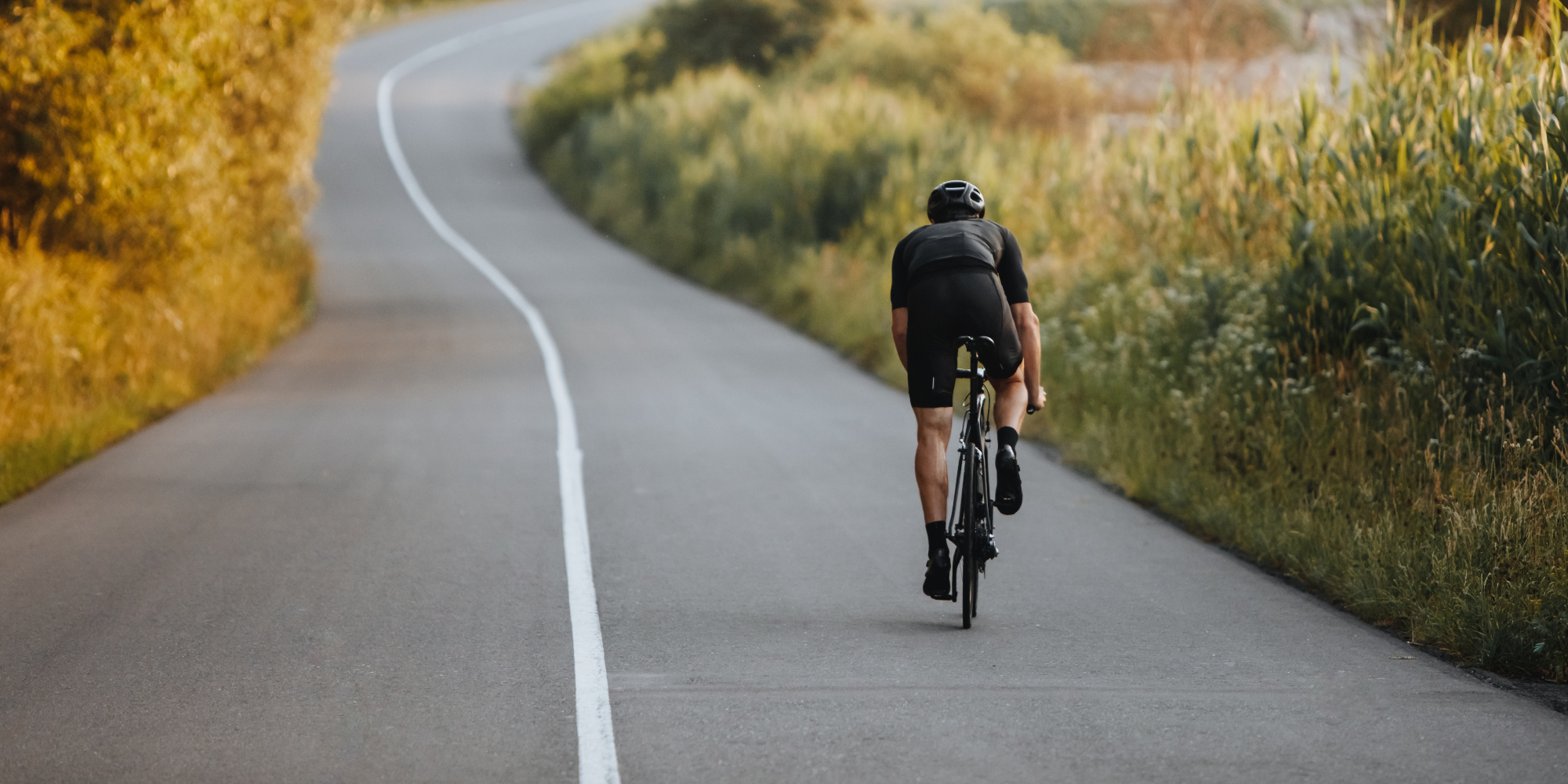 Fahrradfahrer fährt mit einem Rennrad auf einer Straße