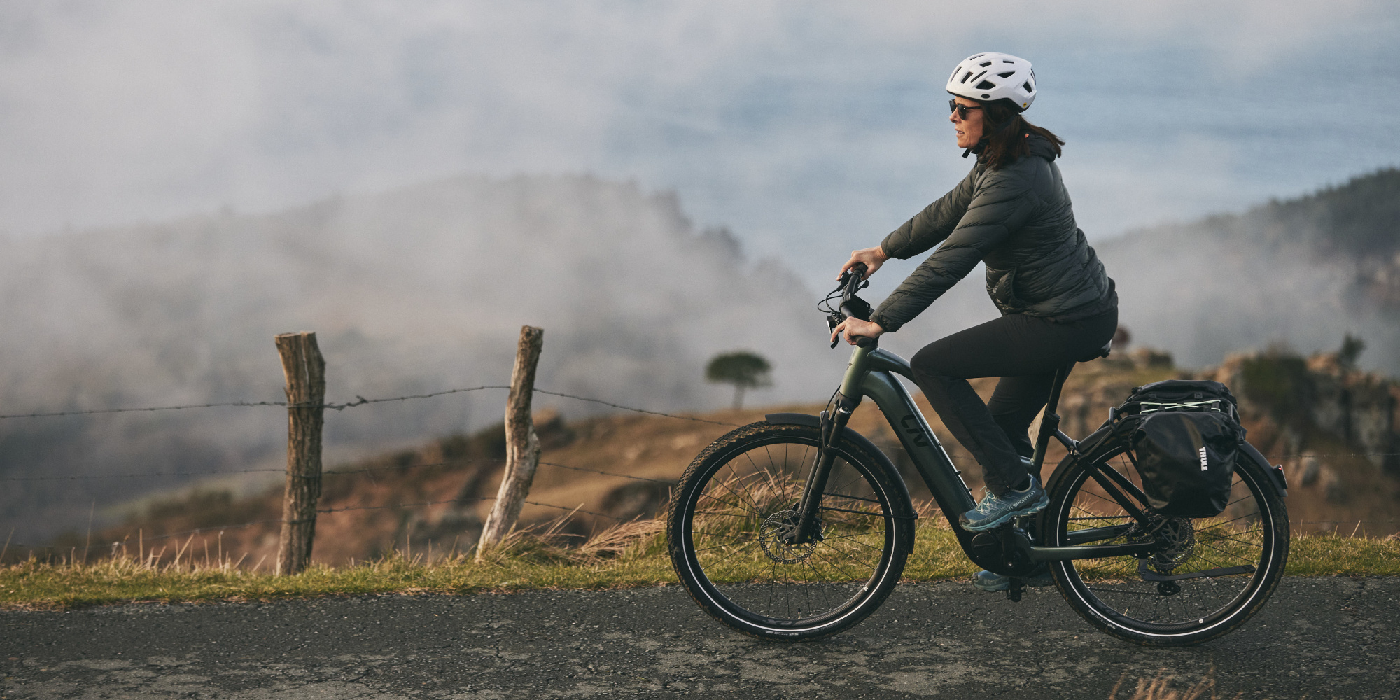 Frau fährt auf einem E-Bike in der Natur