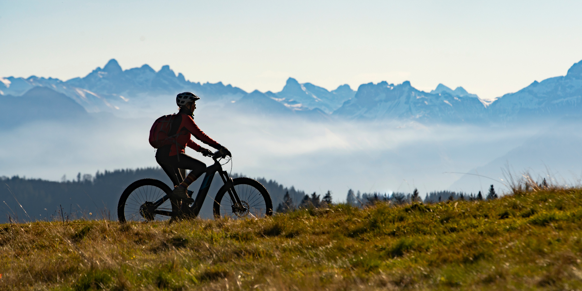 Frau fährt auf einem E-Bike durch die Berge