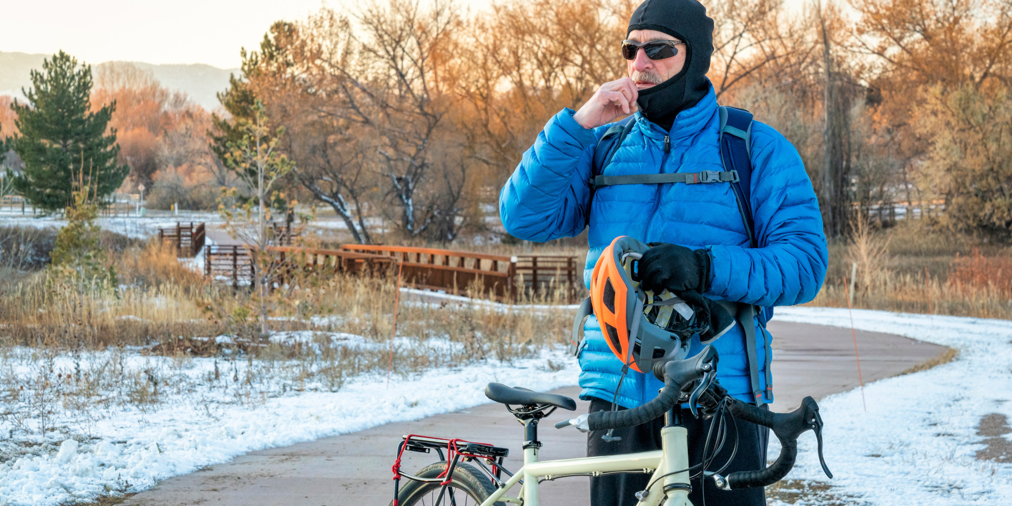 Mann fährt auf einem Fahrrad durch eine winterliche Umgebung mit Schnee.