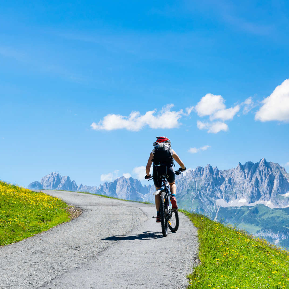 Person fährt auf dem Fahrrad in den Alpen