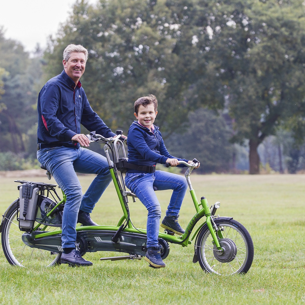 Ein Mann und ein Kind sitzen auf einem Tandem.