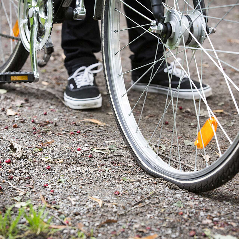 Mensch geht mit seinem Fahrrad spazieren.