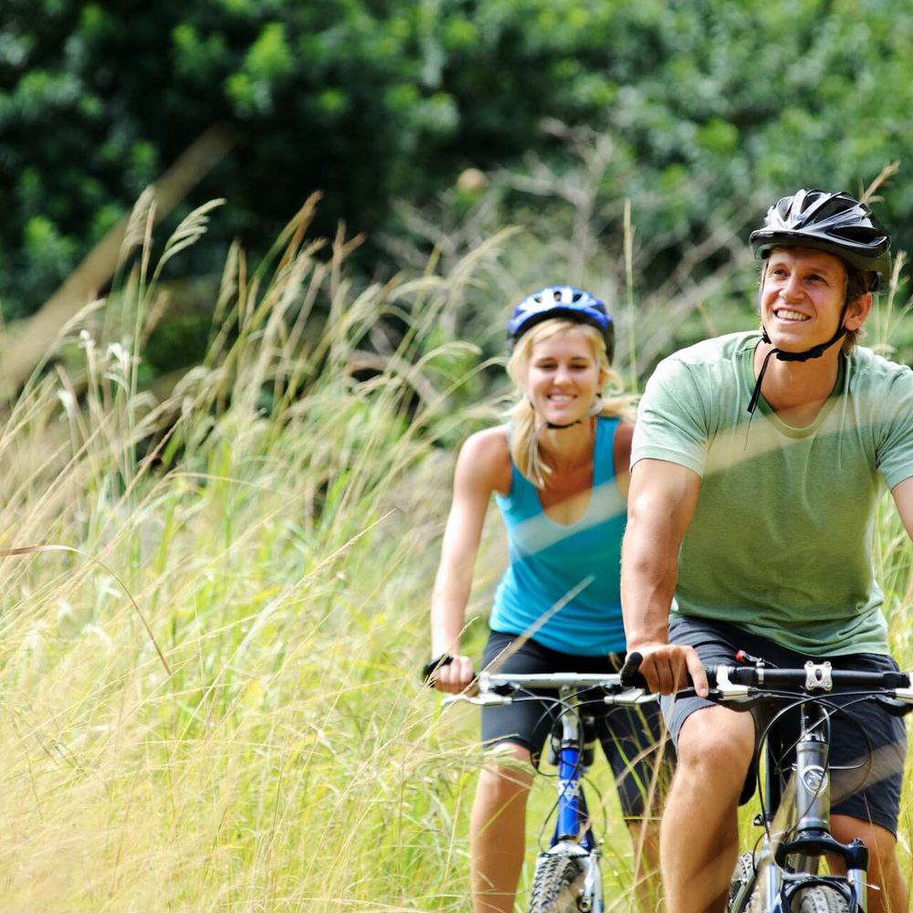 Zwei Personen fahren mit dem Fahrrad in der Natur.