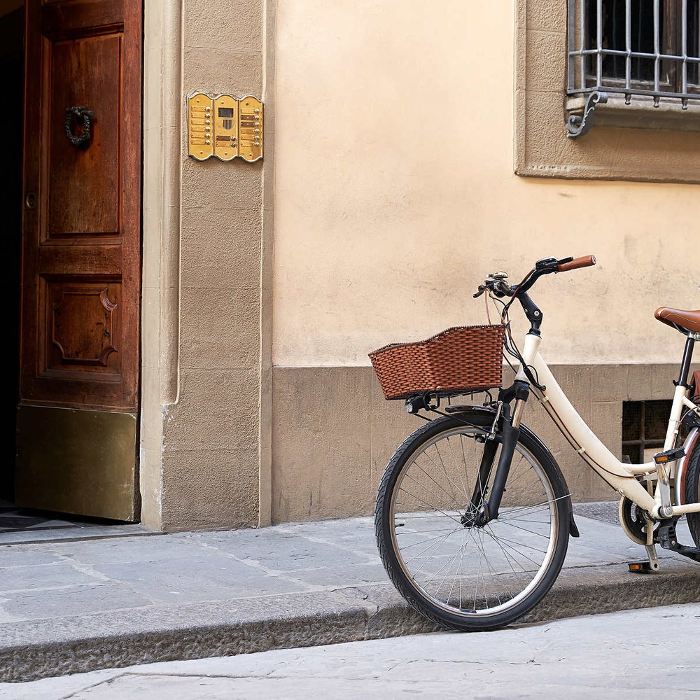 Fahrrad mit Korb und Fahrradtaschen vor einem Haus