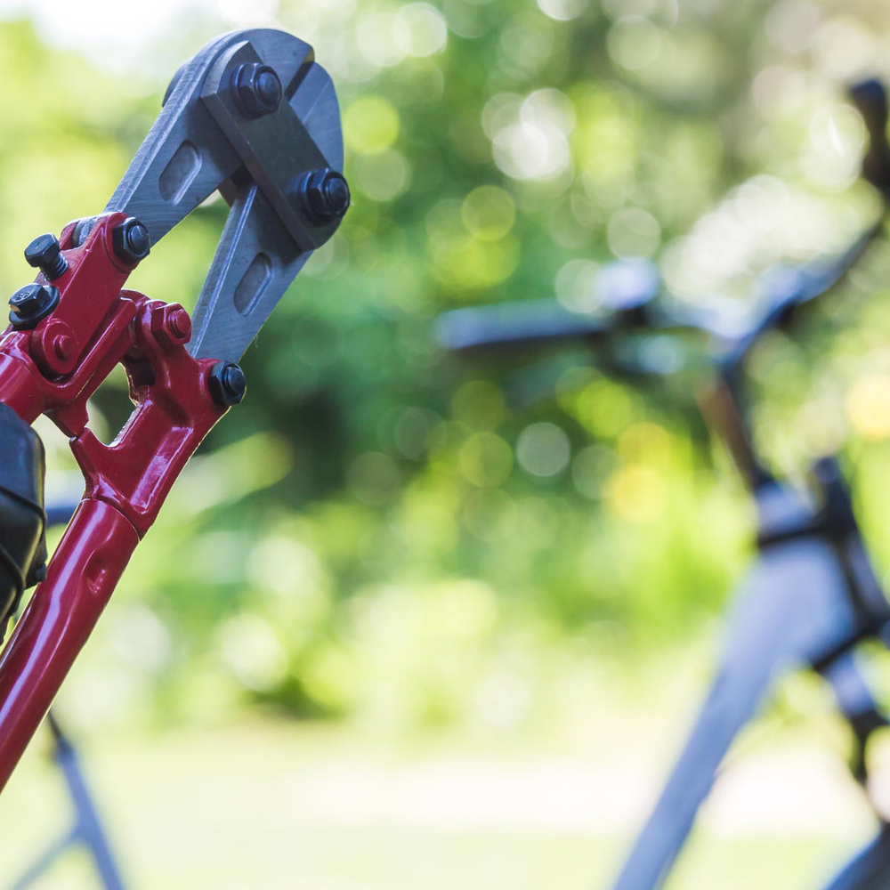 Bolzenschneider wird vor Fahrrad gehalten.