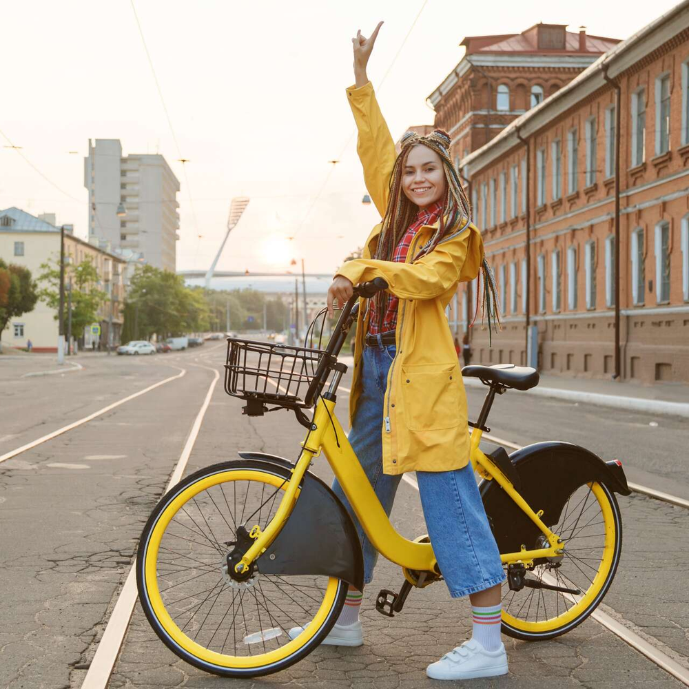 Eine Frau sitzt auf einem Fahrrad und hebt die Hand.