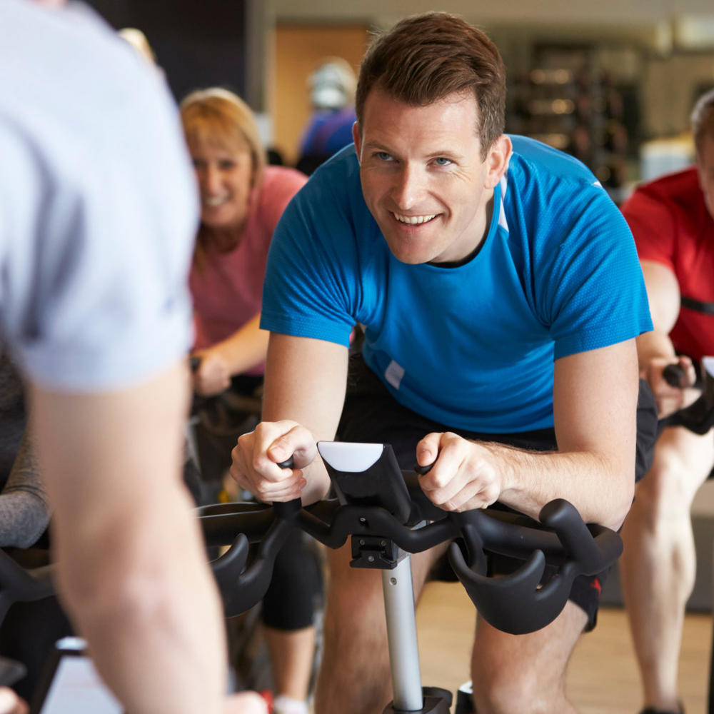 Mehrere Personen machen zusammen Sport auf Spinning-Bikes.